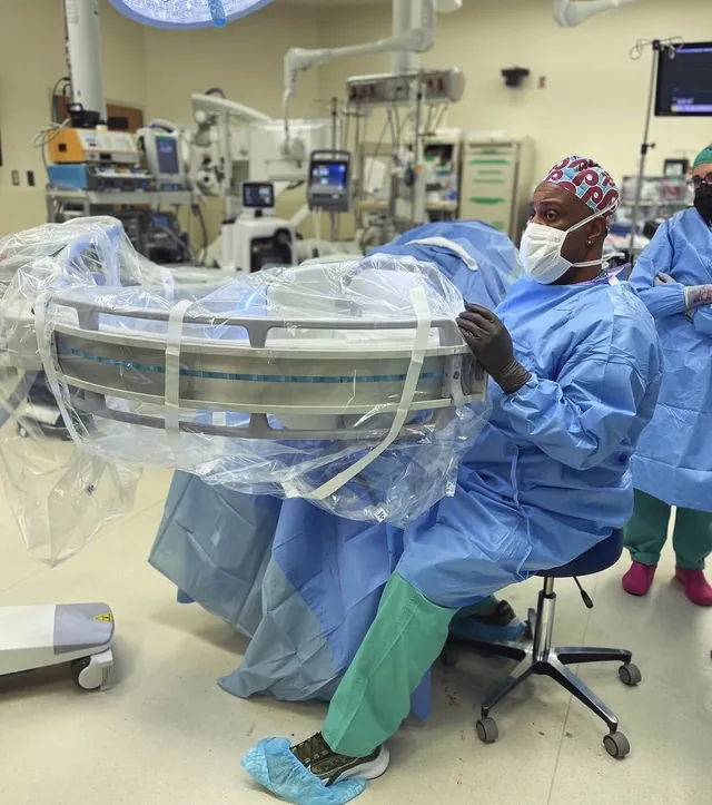 Dr. Cedeno positioning a mobile imaging arm in the operating room